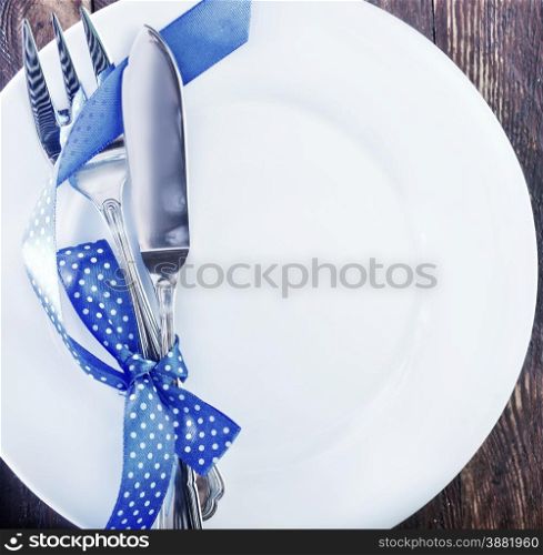 fork and knife on white plate and on a table