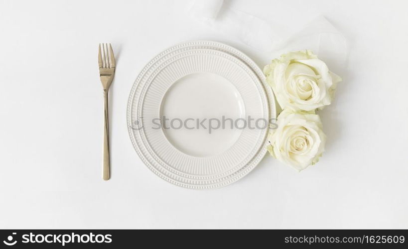 fork ceramic plate roses satin ribbon white background