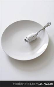 Fork with measuring tape on a plate