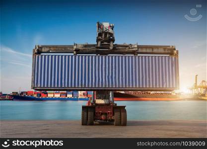 Forklift handling container box loading at port cargo at sunset