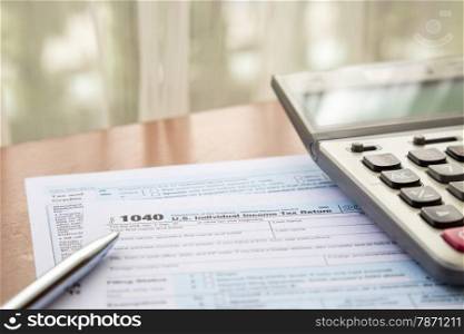 Form 1040, U.S. Individual income tax return place on table with calculator and pen