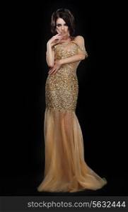 Formal Party. Glamorous Fashion Model in Elegant Golden Dress over Black