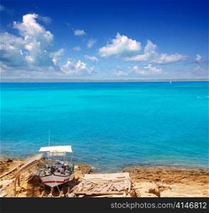 Formentera Es Ram beach with traditional boat and turquoise water