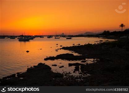 Formentera sunset in Estany des Peix boats with Ibiza Es vedra in Background