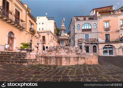 Fountain on the square Piazza Duomo in Taormina on rainy morning, Sicily, Italy. Piazza Duomo in Taormina, Sicily, Italy