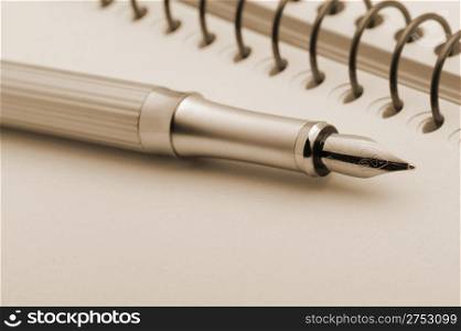 Fountain pen on a yellow notebook. Photo closeup