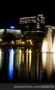 Fountains lit up at night in front of buildings, Orlando, Florida, USA