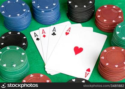 Four aces and poker stacked chips of many colors
