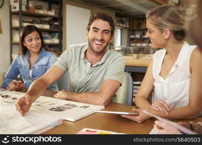 Four Architects Sitting Around Table Having Meeting