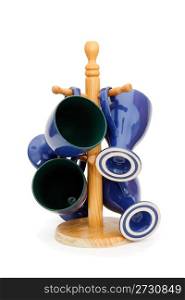 Four blue long-stemmed coffe cups on wooden rack isolated
