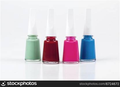 Four bottles of nail polish with different colors