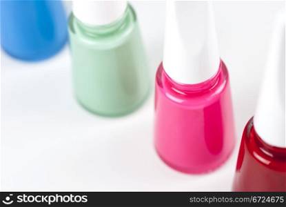Four bottles of nail polish with different colors