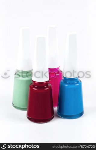 Four bottles of nail polish with different colors