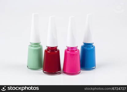 Four bottles of nail polish with different colors