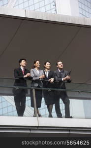 Four Business Colleagues Having Discussion Outside Office Building