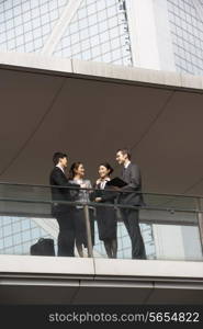 Four Business Colleagues Having Discussion Outside Office Building