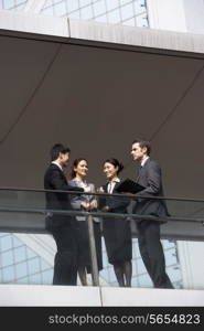 Four Business Colleagues Having Discussion Outside Office Building