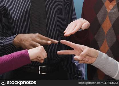 Four business executives making hand signs