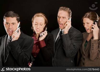 Four business executives talking on mobile phones