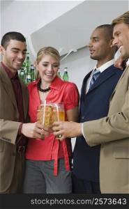 Four business executives toasting with glasses of beer in a party