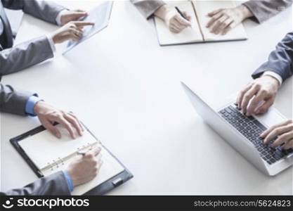 Four business people around a table and during a business meeting, hands only