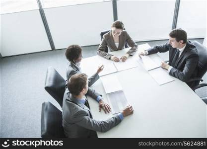 Four business people sitting around a table and having a business meeting, high angle view