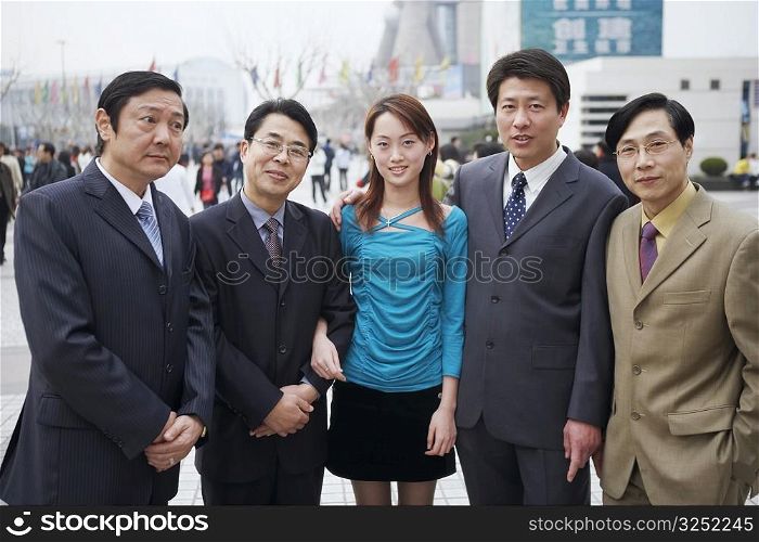 Four businessmen standing with a young woman