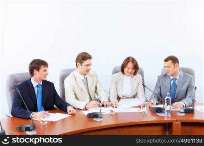 Four businesspeople at meeting. Image of four businesspeople discussing at meeting