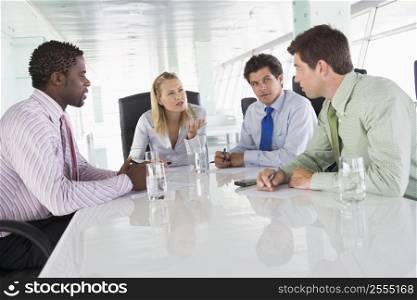 Four businesspeople in a boardroom talking