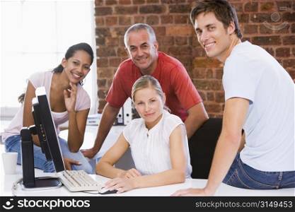 Four businesspeople in office space smiling
