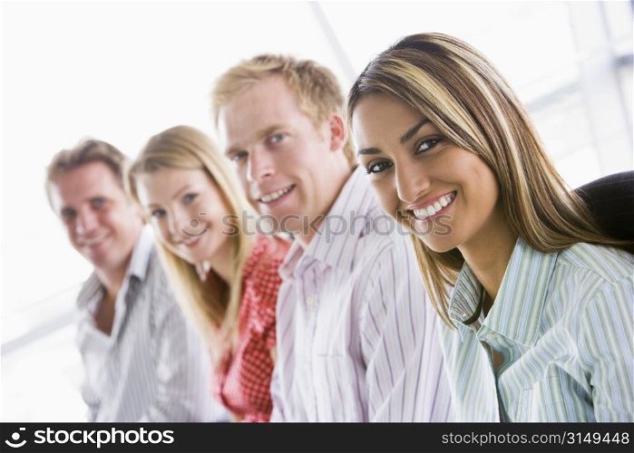 Four businesspeople sitting indoors smiling