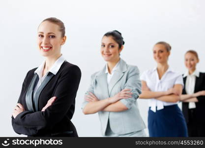 Four businesswomen standing in row. Image of four pretty young businesswomen standing in row