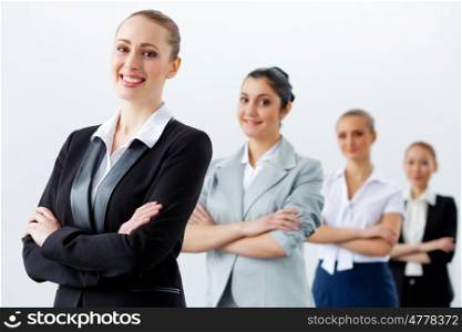 Four businesswomen standing in row. Image of four pretty young businesswomen standing in row