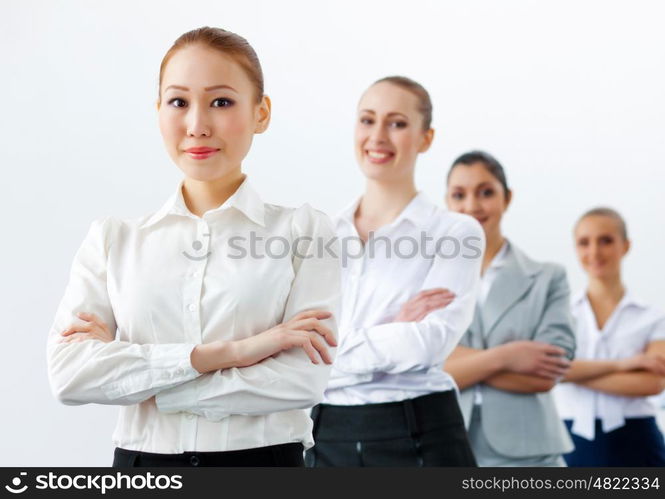 Four businesswomen standing in row. Image of four pretty young businesswomen standing in row