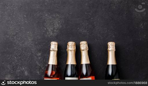 Four champagne bottles on dark background, flat lay, celebration concept. Four champagne bottles on dark background, flat lay