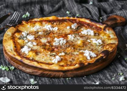 Four cheese pizza quattro fromaggi on a rustic wooden board background