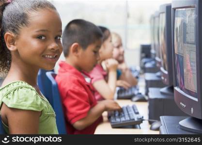 Four children at computer terminals (depth of field/high key)