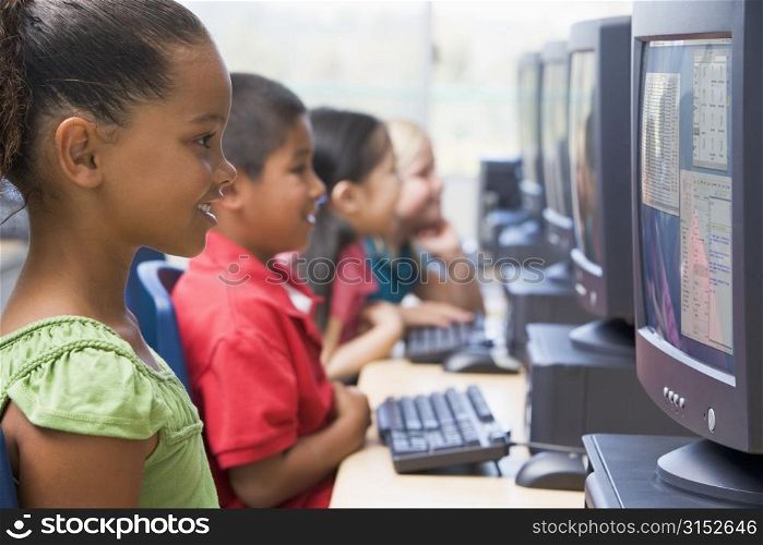 Four children at computer terminals (depth of focus/high key)