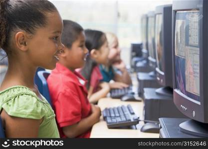 Four children at computer terminals (depth of focus/high key)