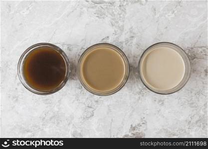 four coffee cups row marble backdrop displaying different mixtures milk coffee