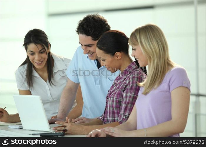 Four colleagues gathered around laptop