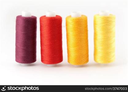 Four colored thread spools isolated on white background&#xA;