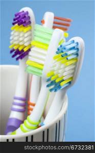 four colorful toothbrushes isolated on blue background