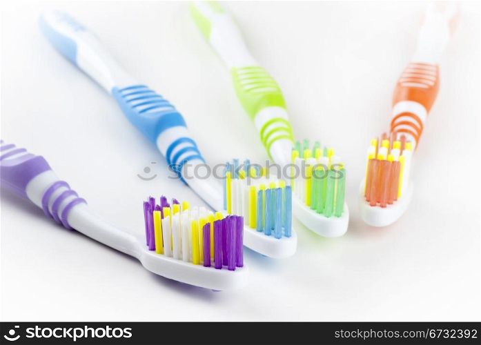 four colorful toothbrushes isolated on white background