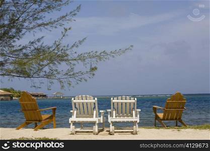 Four deck chairs on the beach, Dixon Cove, Roatan, Bay Islands, Honduras