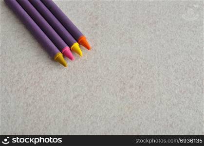 Four different color wax crayons with a white background