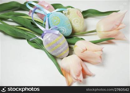 Four easter eggs with three tulips to depict easter