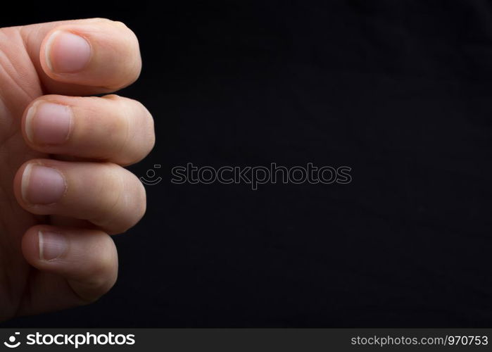 Four fingers of a child hand partly seen in black background