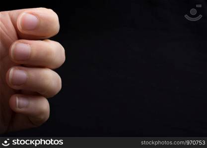 Four fingers of a child hand partly seen in black background