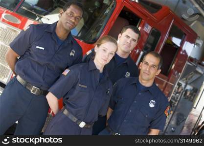 Four firefighters standing in front of fire engine
